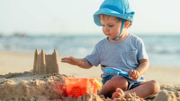 Child building a sandcastle on a beach
